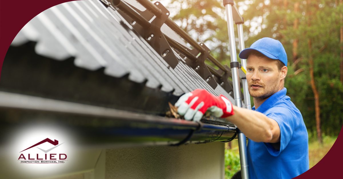 Cleaning debris from a home’s gutter.