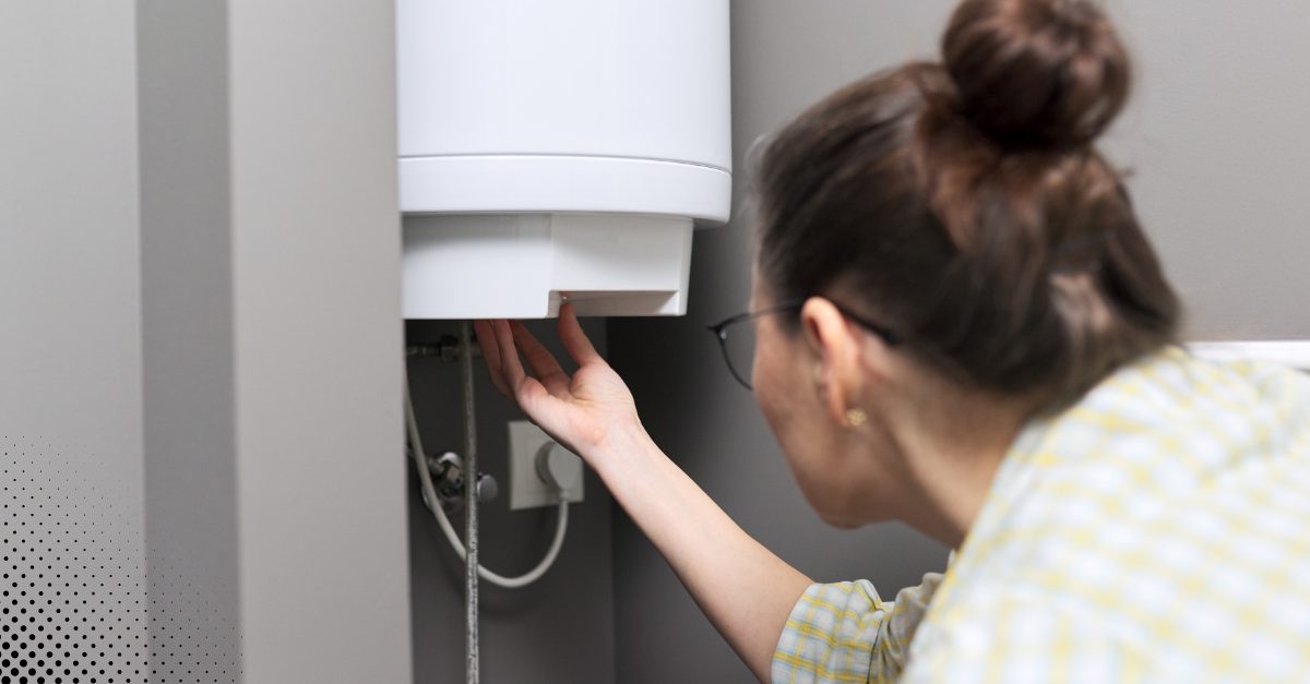 Woman checking the bottom of a water heater for leaks.