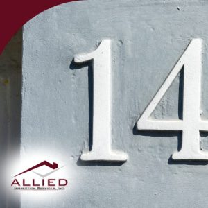 White house number 143 painted on a gray wall